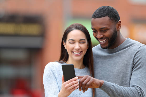 istock Happy interracial couple consulting phone text 1395004625