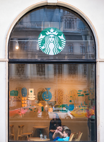 Bucharest, Romania - 04.08.2022: Photo through the windows of Starbucks coffeehouse chain store at University Square in the center of Bucharest