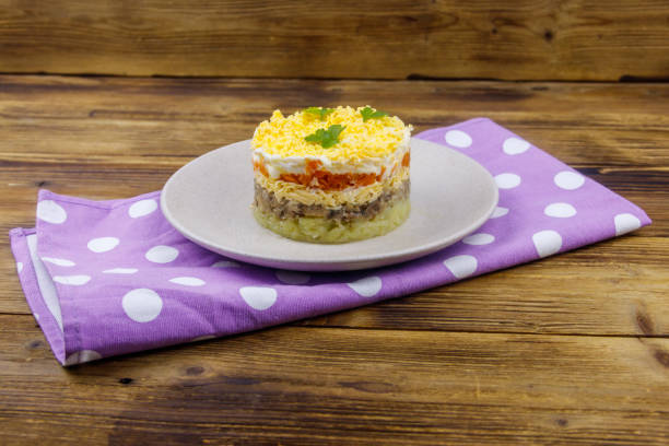 istock Traditional russian salad Mimosa on wooden table 1395005607