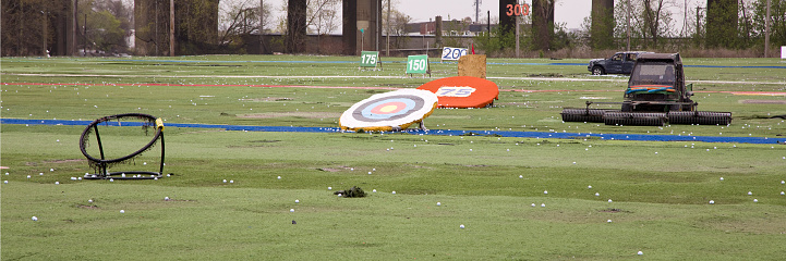 Man practicing archery and using bow and arrow to hit the target in the desert. Hobby and leisure with vacation concept