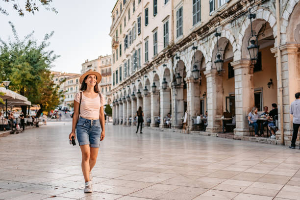 Young Female Tourist Enjoying The Greek Architecture Beautiful young female tourist enjoying the architecture of Corfu Town, Greece. corfu town stock pictures, royalty-free photos & images