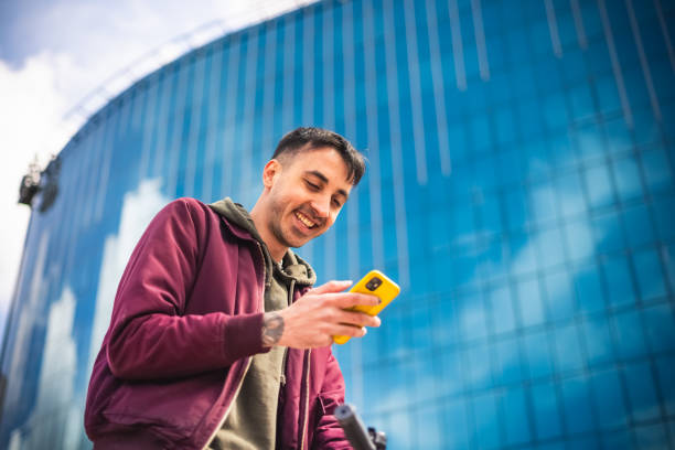 istock Young man using mobile phone in the city 1395010222