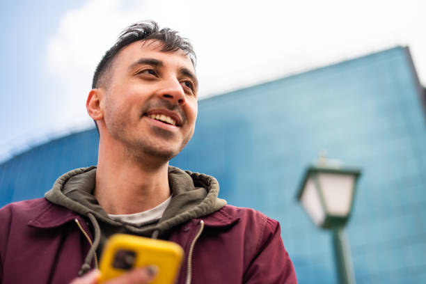 istock Young man using mobile phone in the city 1395010427