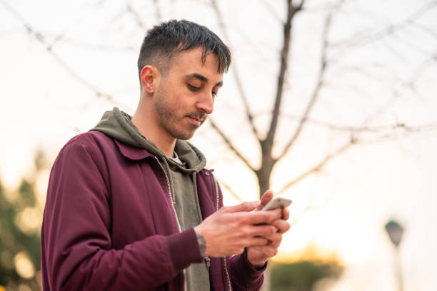 istock Young man using mobile phone outdoors 1395010804