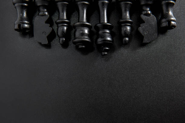 Chess game, wooden pieces on black background.
