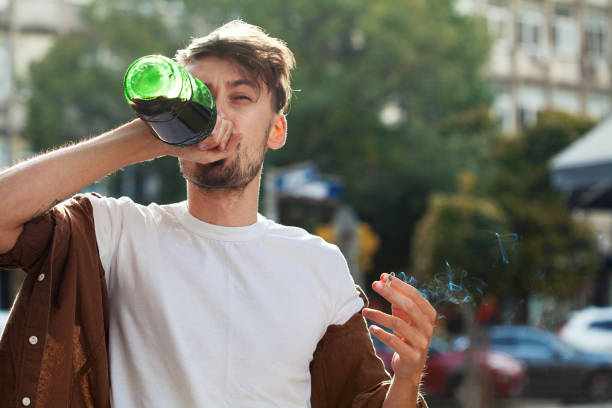 istock Young man drinking red wine and smoking 1395015327