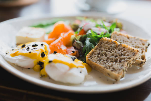 Delicious breakfast snack - salad with arugula and radish egg vegetables and grilled bread and slice of salmon