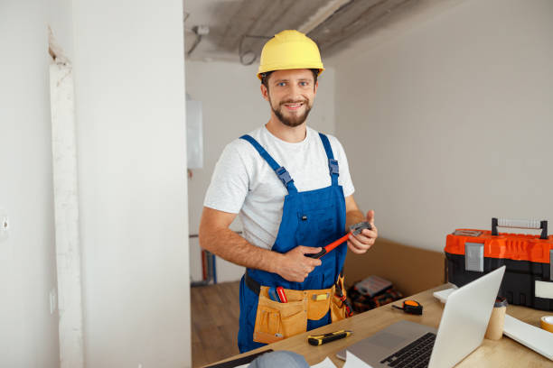 istock Professional handyman worker in uniform wearing tool belt and hardhat smiling at camera, holding hammer during renovation work indoors 1395015797