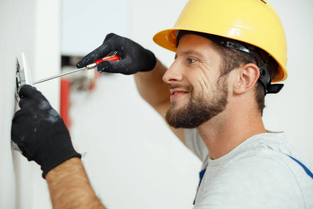 istock Smiling professional electrician in uniform replacing a socket in apartment after renovation work 1395015848