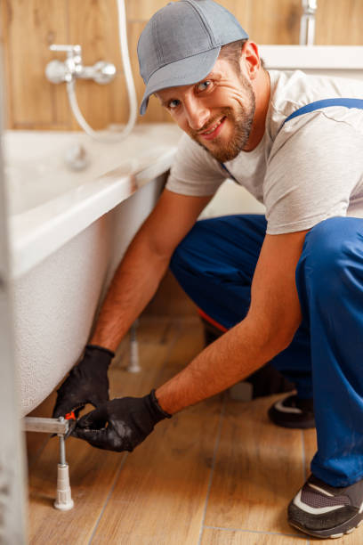 istock Cheerful plumber or technician smiling at camera while installing a bathtub in bathroom 1395015908