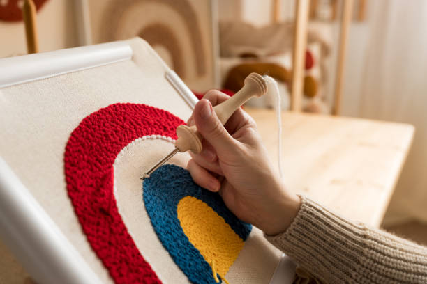 close up of woman creating a handmade decoration for home. female pushing the punchneedle straight down into the fabric. hobby, diy, handycraft concept. new trend in embroidery punch needle. - burlap canvas home decorating color image imagens e fotografias de stock