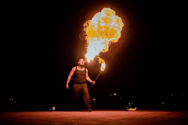 istock Male fire-eater blowing big flames 1395019301