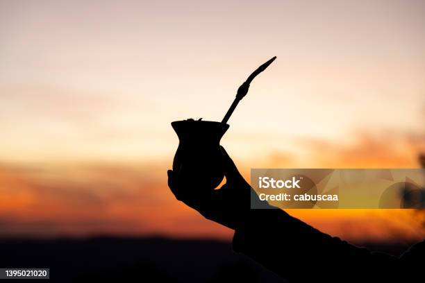 Silhouette Of A Hand Holding A Yerba Mate Gourd Drink At Sunset Stock Photo - Download Image Now