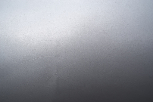 Close-up gray white blue scratched dark shine metal panel with color gradient, background texture, full frame