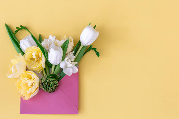 istock Flowers in an envelope on a colored background, flat lay. 1395026408