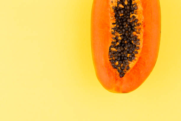 istock Half ripe papaya fruit with seeds on yellow background, copy space, flat lay 1395027190