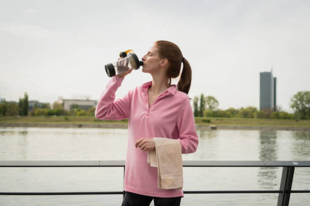 istock Healthy woman drinking water after exercising 1395027193