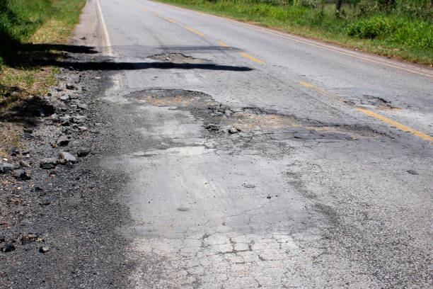 istock highway with damaged asphalt unsuitable for driving 1395027573