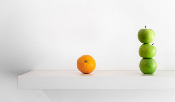 istock Green apples and orange on a white background close-up. 1395028421