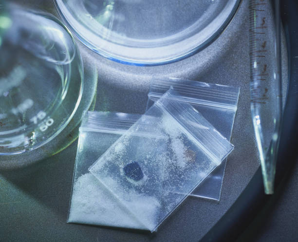 fentanilo opiáceo heroína metanfetamina en laboratorio con vasos de precipitados en bolsas con píldora y polvo - fentanyl fotografías e imágenes de stock