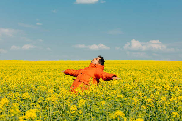 istock Stylish man in orange jacket in rapeseed field 1395030720