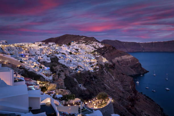 vista panorâmica da vila iluminada oia - sea aegean sea night illuminated - fotografias e filmes do acervo