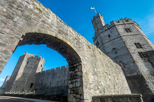 Caernarfon,North Wales,UK-March 17 2022: One of the greatest buildings of the Middle Ages,with polygonal towers, eagle statues and multi-coloured masonry,on a sunny spring day.
