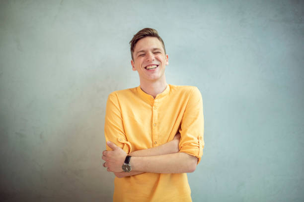 istock A smiling man stands with folded arms in front of a white background. 1395040302
