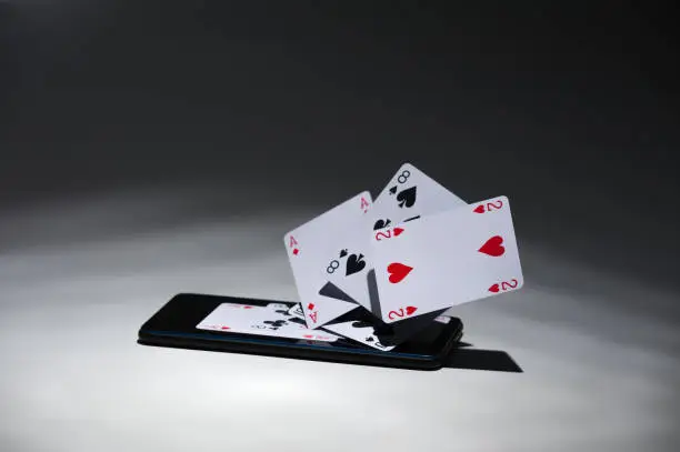 phone and playing cards emerging from there