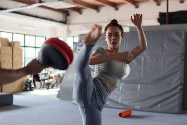 istock Asian chinese woman practising kicking during martial arts class 1395049038