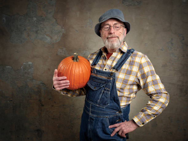 istock senior, bearded man with a pumpkin 1395050724