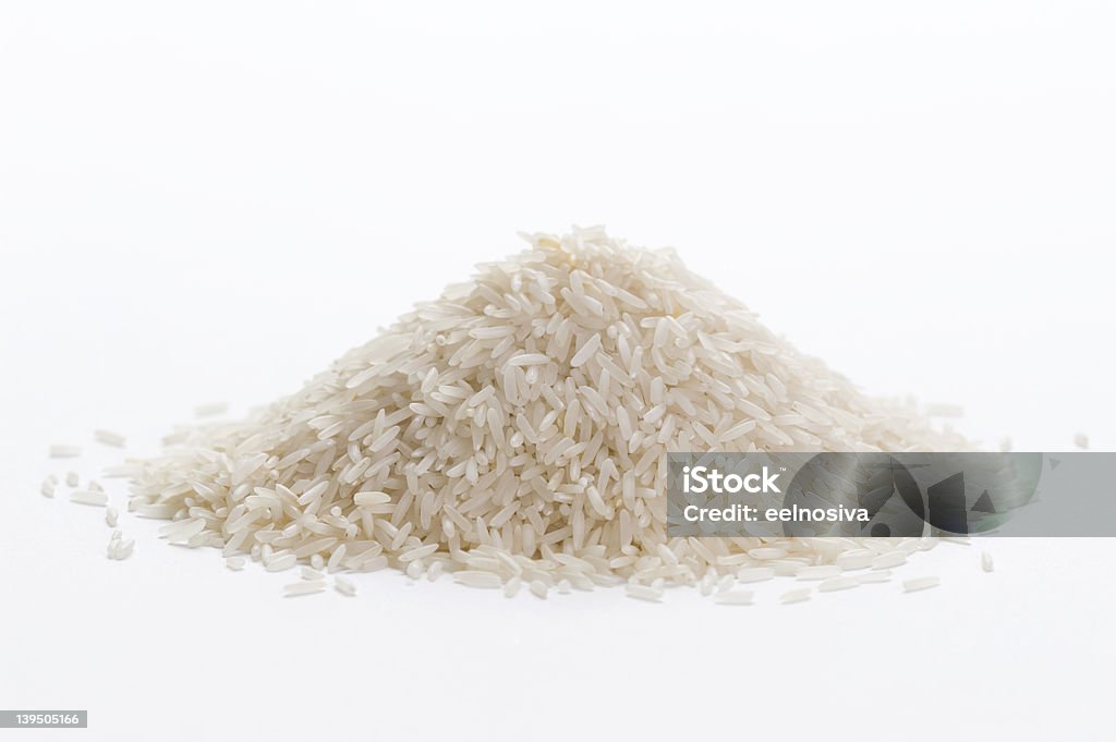 basmati rice uncooked basmati rice in a small pile on a white background Rice - Food Staple Stock Photo