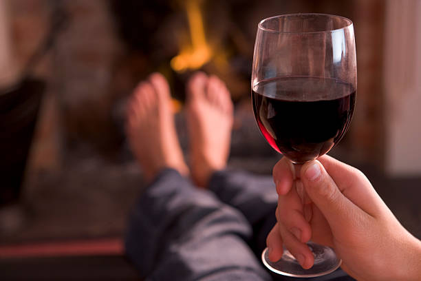 istock Feet warming at fireplace with hand holding wine 139505182
