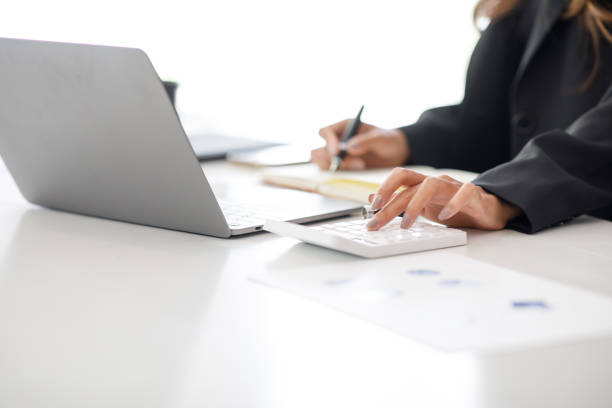 istock Business woman using calculator and laptop 1395053055