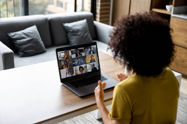 mujer hablando con algunos colegas en una reunión de negocios en línea mientras trabaja en casa - entrevista fotografías e imágenes de stock
