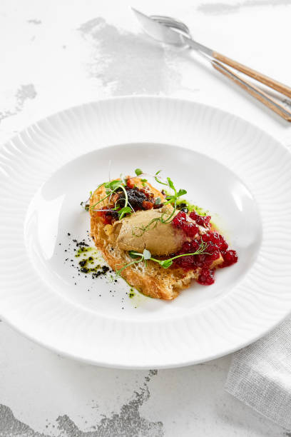 istock Chicken liver pate on crispy bread with red currant jam and micro green. Bruschetta with chicken pate in white plate. Delicious appetizer - foie gras on toast. Liver pate with jam in rustic style. 1395059009