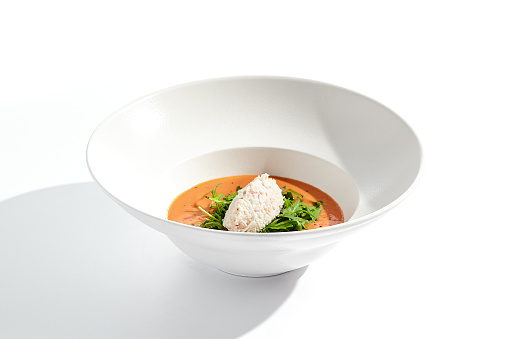 Summer Spanish soup gazpacho with crab meat and rucola isolated on white background. Delicious cold tomato soup with crab. Clean eating for diet.Healthy food in restaurant menu. Crab gazpacho