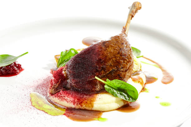 istock Delicatessen dish - duck leg confit with mashed potatoes and cabbage steak. Duck confit with vegetables and wine gravy on white plate. Gourmet meal in restaurant menu. Fusion main course. 1395060541
