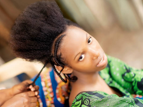 Young afro beauty being braided, teenage girl, eighteen years old Young afro beauty being braided, teenage girl, eighteen years old black woman hair braids stock pictures, royalty-free photos & images