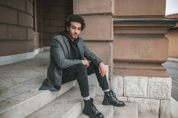 istock Young man is sitting on the stairs 1395065317