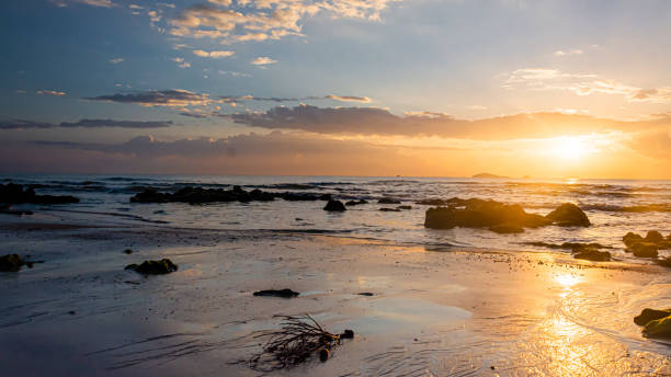 istock sunset landscape on the beach rocks in foreground 1395070926