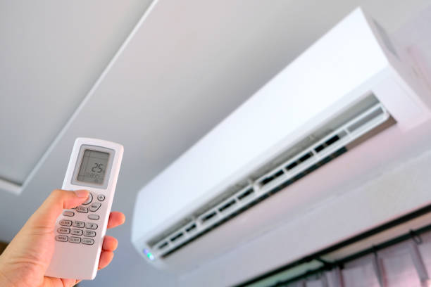 istock Man's hand using remote control open The air conditioner is cooled to 25 degrees Celsius in his bedroom. Health concepts and energy savings 1395071348