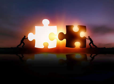 Two businessmen put two puzzles together. Teamwork, cooperation and cooperation concepts