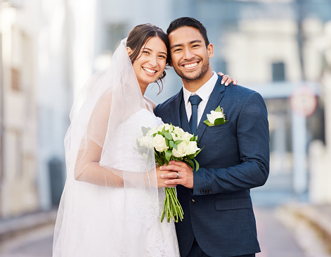 Beautiful young bride and groom outside in field