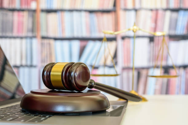 Legal office of lawyers, justice and law concept : Judge gavel or a hammer and a base used by a judge person on a desk in a courtroom with blurred weight scale of justice, bookshelf background behind oficina legal de abogados, justicia y concepto de ley: juez gavel o un martillo y una base utilizada por una persona de juez en un escritorio en una sala de audiencias con una escala de peso borrosa de justicia, fondo de estantería detrás
