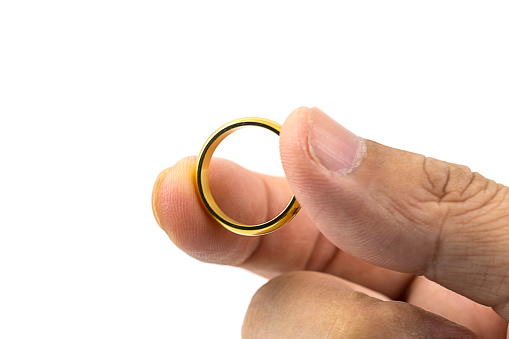 Closeup photo of  golden wedding ring on hands isolated on white background