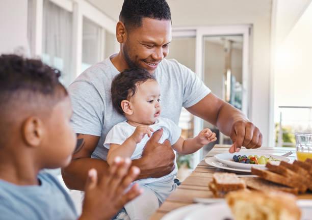 Shot of a young family having lunch together at home Can I have some? 3 6 months stock pictures, royalty-free photos & images