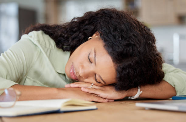 istock Shot of a young woman sleeping at a table while working from home 1395081666