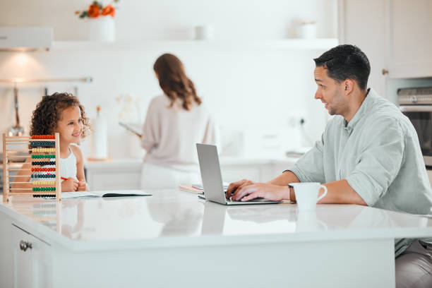 istock Shot of a young father working from home while his daughter does homework in the kitchen 1395082969