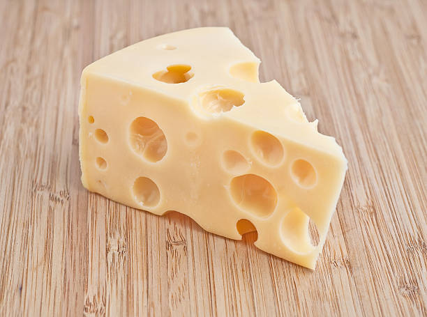 istock Triangular chunk of very holey cheese on a wooden surface 139508325